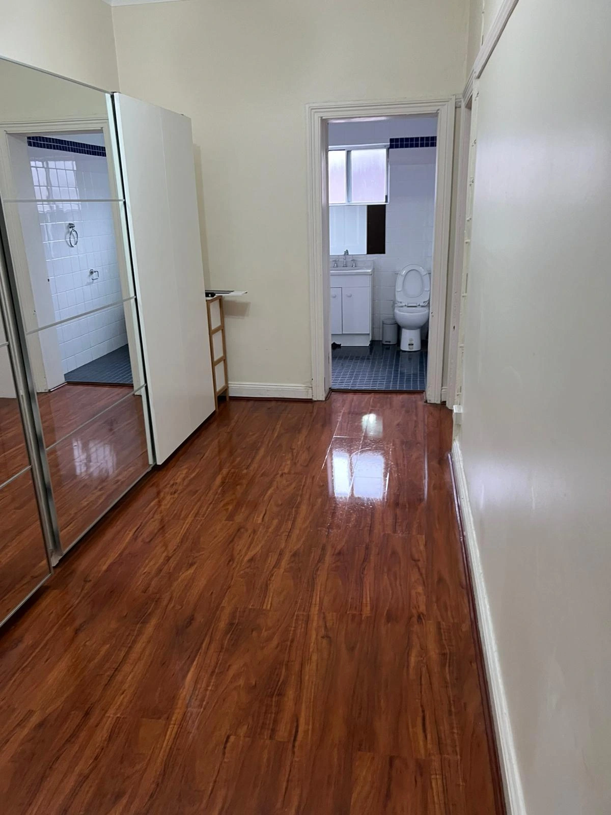 Empty rental room with spotless floors and neat windows after a detailed bond cleaning service.